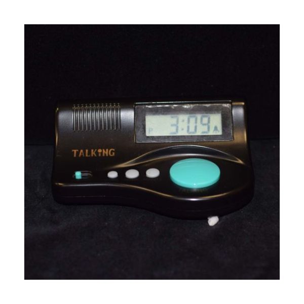 A small black clock features several differently-sized control buttons and an angled LCD display for the time.