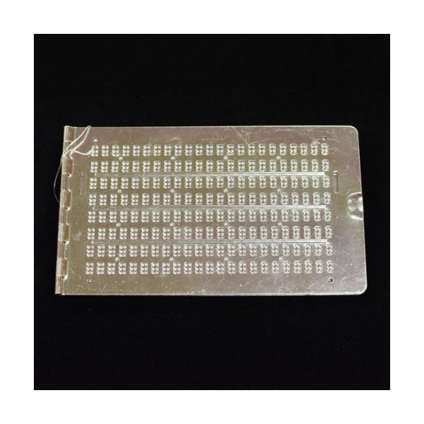 An 18-line aluminum slate with 23 cells per line and a Dymo tape slot at each end.