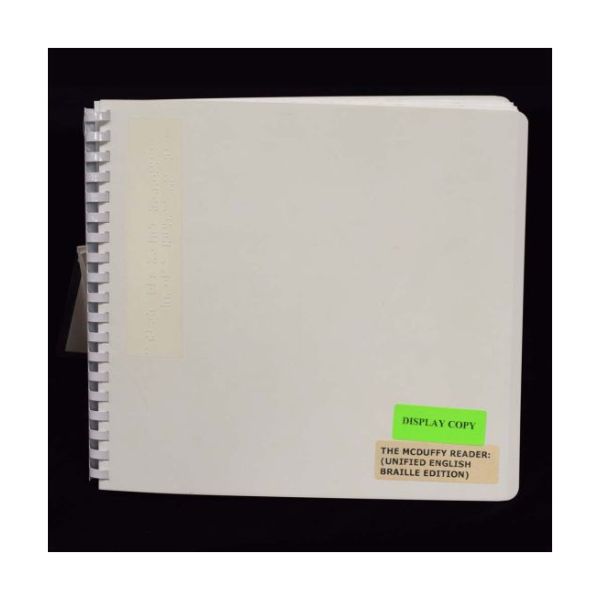 A Braille book bound with a white plastic comb.