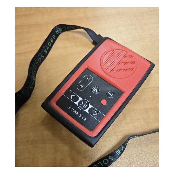 A red and black audio player with tactile buttons and a carrying strap.